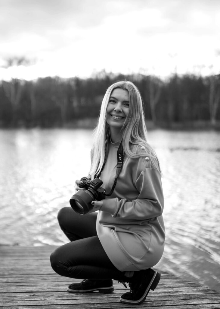 Fotografin Marina lächelt in die Kamera. Schwarz/Weiß Bild. 