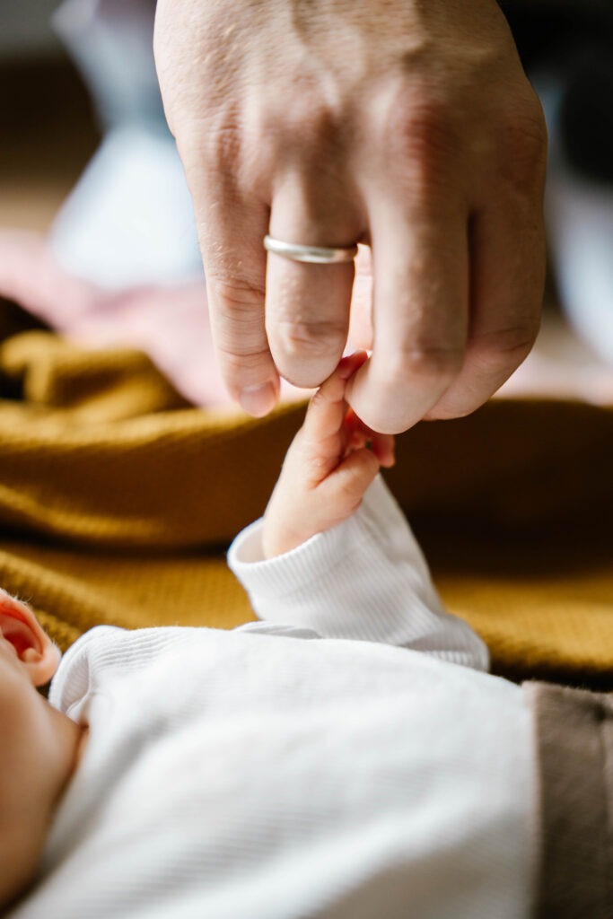 Finger von Baby greift Paps Finger